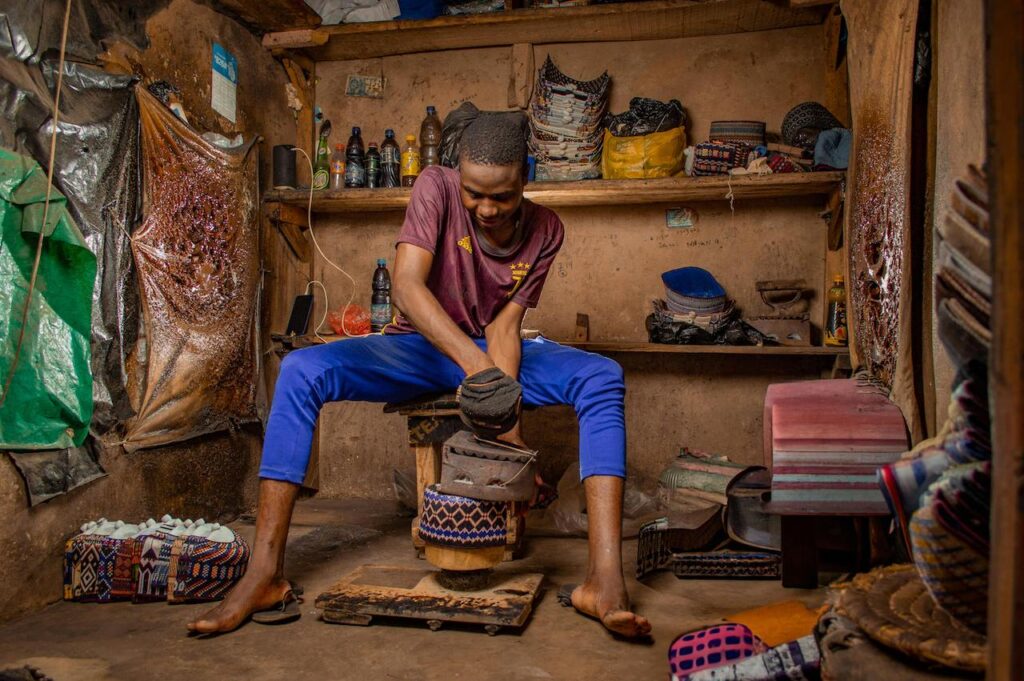A craftsman works on handmade products in a workshop, showing small business operations.